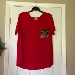 Red short-sleeve shirt with contrasting leopard pocket.